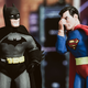A photo shows a Superman doll face-palming while Batman stares blankly at him.